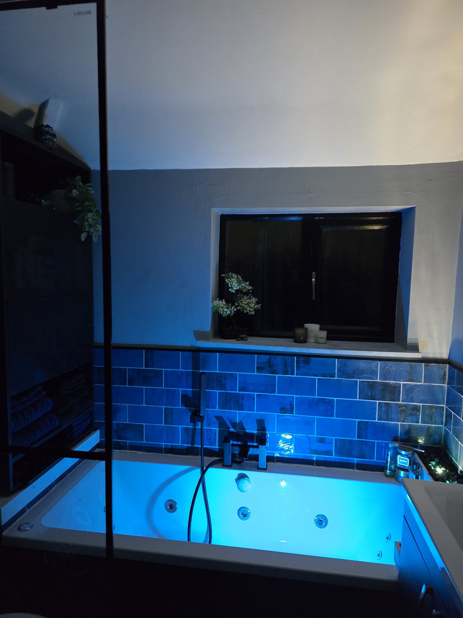 Bathroom with blue tiling and fitted bath surround